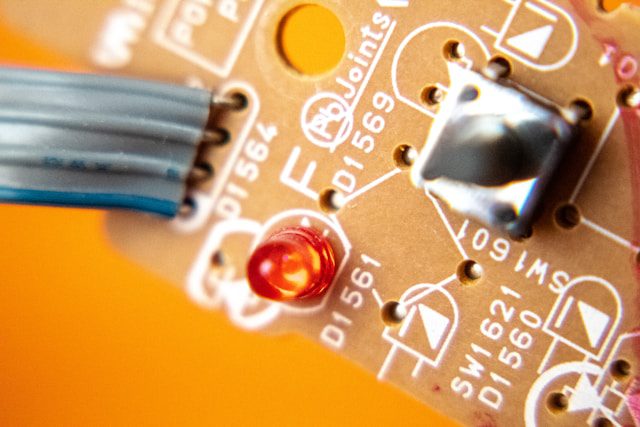 A silver and orange circuit board. 