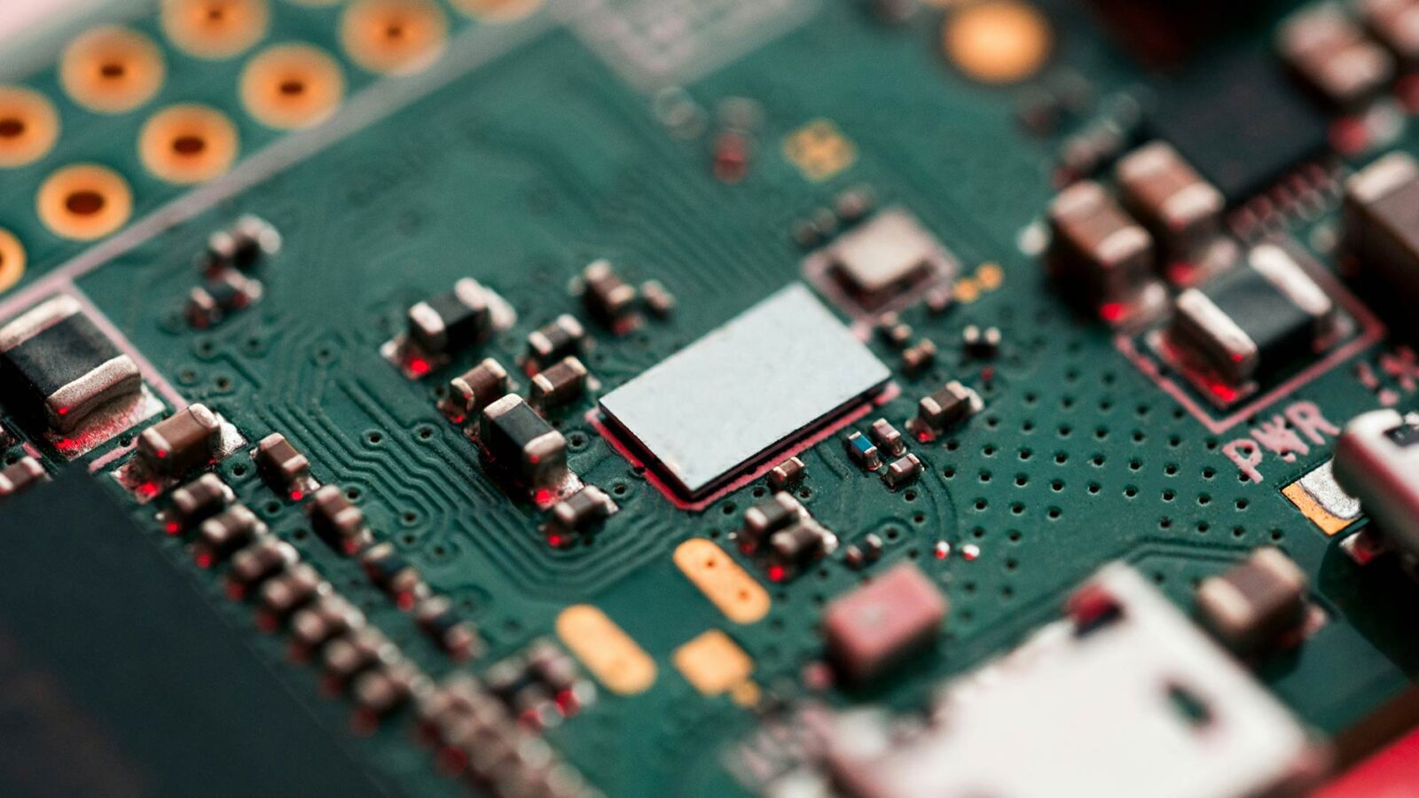 A close-up photo of a computer circuit board with copper finishes.