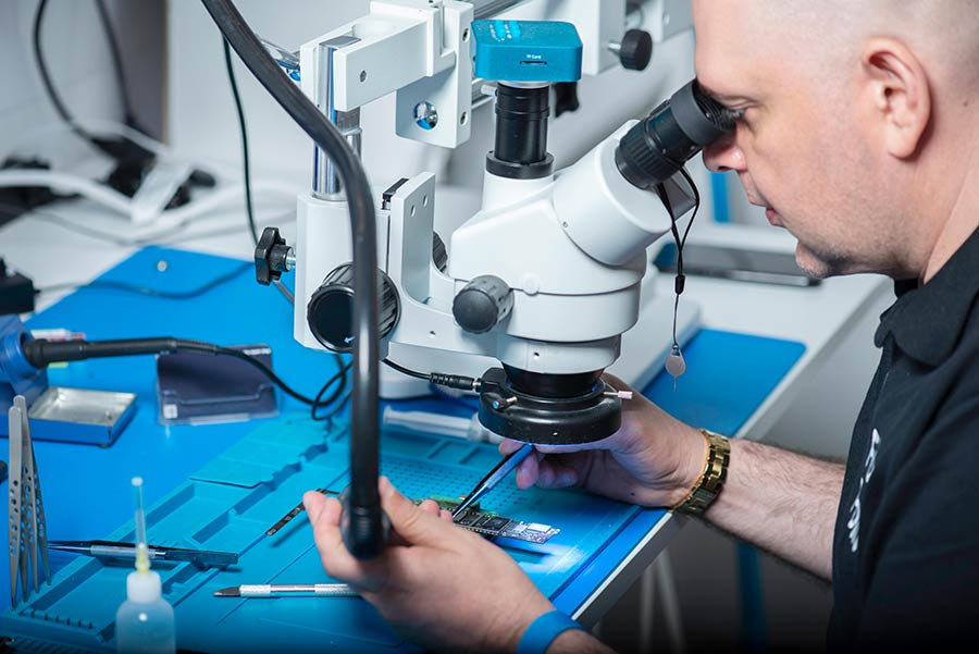 Electronics technician inspecting a PCB.