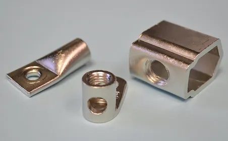 Three metal parts with a smooth, reflective nickel finish.