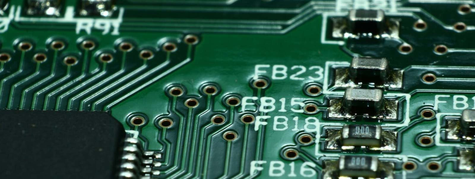 A green computer circuit board with silver-plated traces.