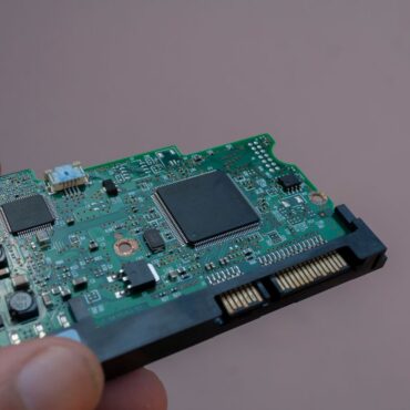 Person holding a small PCB assembly.