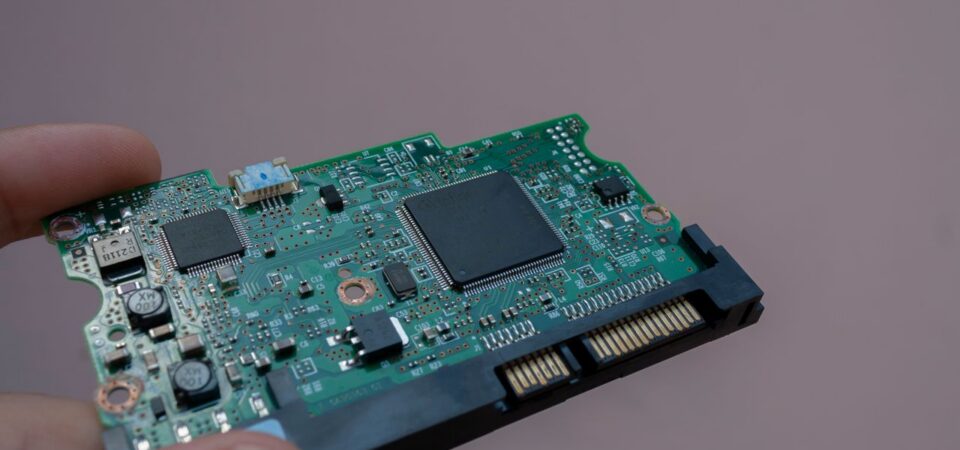 Person holding a small PCB assembly.